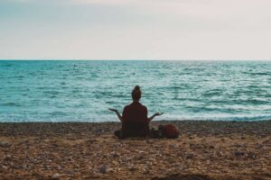 woman meditating on a beach cbt in wakefield