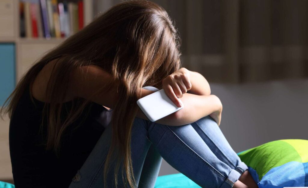 sad teen holding phone therapy in wakefield