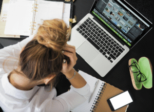 A stressed woman looking at a laptop screen